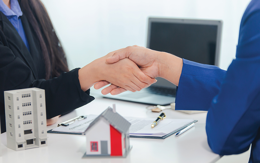 Lender and buyer shaking hands at a table